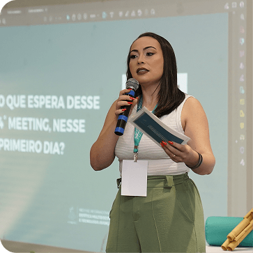 Fundadora conduzindo apresentação no palco